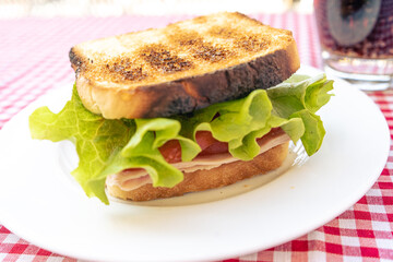 Delicious toasted ham, tomato and lettuce sandwich.