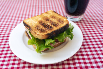 Delicious toasted ham, tomato and lettuce sandwich.
