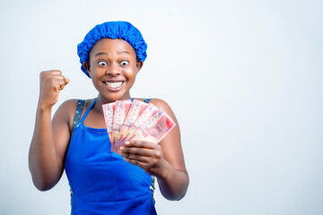 image of excited young african lady with bank notes- beautiful black girl in apron with ghana...