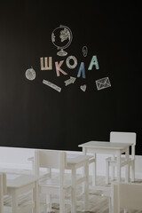 Empty classroom with with chalk lettering school in Russian. Back to school