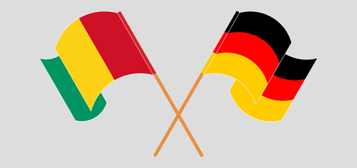Crossed and waving flags of Guinea and Germany