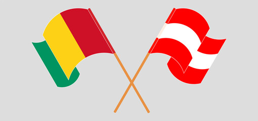 Crossed and waving flags of Guinea and Austria