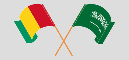 Crossed and waving flags of Guinea and the Kingdom of Saudi Arabia
