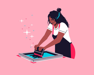 Screen printing artist. silkscreen printing technique. female printmaker using traditional printmaking method to transfer ink to paper and textile using squeegee.