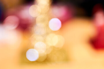 Abstract bokeh out of focus background of gold tinsel small decorative christmas tree. Christmas...