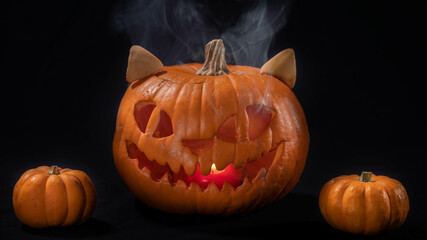 Illuminated jack o lantern halloween pumpkins, on black background	