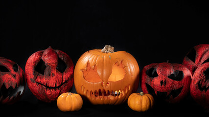 Illuminated jack o lantern halloween pumpkins, on black background	