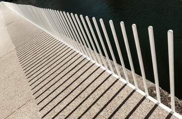 Abstract view of modern iron fence with its shadow.