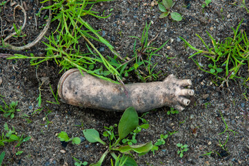 hand of an old doll on a rock