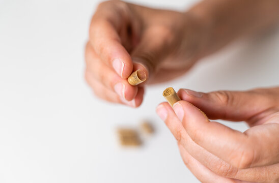 Close up hand with herb capsule on white background. Microdosing concept. Psychedelics therapy. Depression, anxiety treatment 