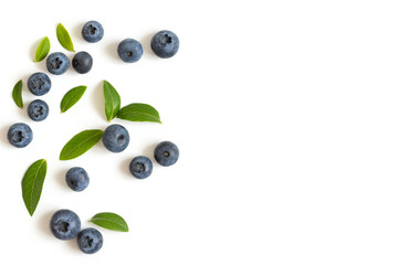 Blueberries and green leaves isolated on a white background. Blueberry border. Top view, copy space.