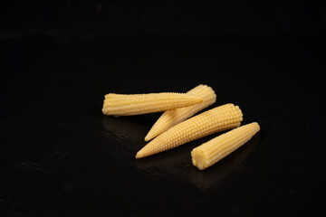 Miniature corn cobs, on black background	