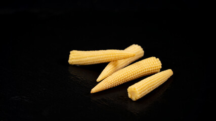 Miniature corn cobs, on black background	