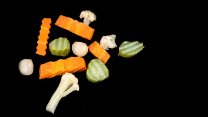 Small pieces of vegetables, sliced ​​in vinegar, on black background	