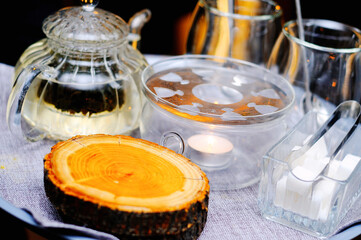 Tray with tea, glasses, sugar, candles and cup holders from the log cabins of the tree. Original tea delivery
