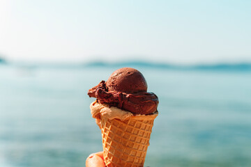 Tasty ice cream in hand on the background the turquoise sea