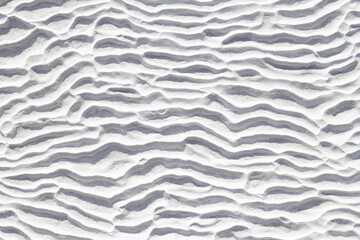 White texture of Pamukkale calcium travertine in Turkey, pattern of horizontal waves, close-up.