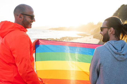 Two gay men hold lgbt flag