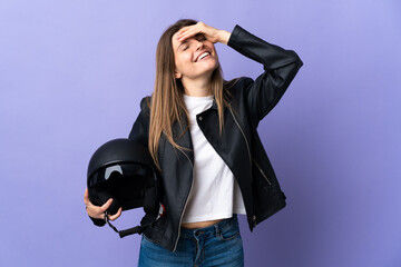 Young slovak woman holding a motorcycle helmet isolated on purple background smiling a lot