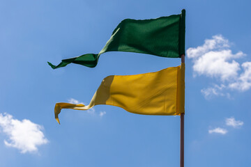 green and yellow pennants fluttering in the wind in the blue sky. Patriotism