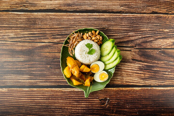 Chicken Curry Nasi Lemak served with coconut rice, cucumber, anchovies, peanuts and eggs 