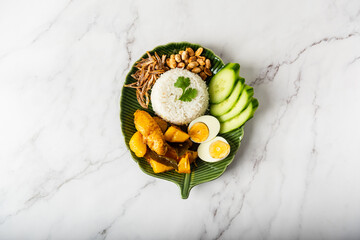 Chicken Curry Nasi Lemak served with coconut rice, cucumber, anchovies, peanuts and eggs  - obrazy, fototapety, plakaty
