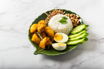 Chicken Curry Nasi Lemak served with coconut rice, cucumber, anchovies, peanuts and eggs 