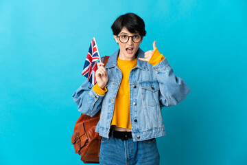 Woman holding an United Kingdom flag over isolated background making phone gesture. Call me back sign