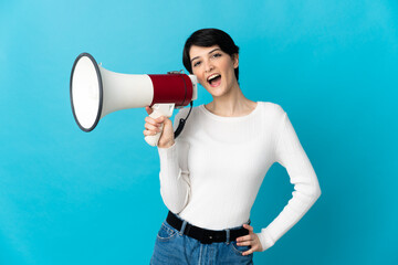 Woman with short hair isolated on blue background holding a megaphone and smiling