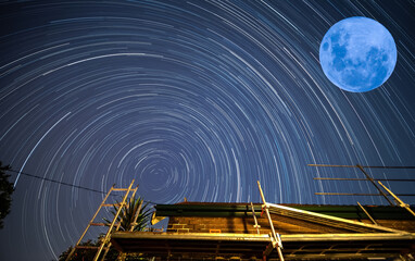 Star trails in a Sydney backyard with house trees and fence in the foreground NSW Australia