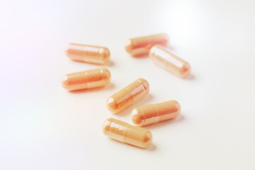 Turmeric capsules. Bright paper background. Close up. 