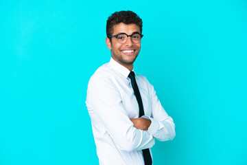 Young business Brazilian man isolated on blue background with arms crossed and looking forward