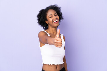 Fototapeta na wymiar Young African American woman isolated on purple background with thumbs up because something good has happened