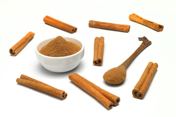 Aromatic cinnamon sticks and bowl with powder on white background