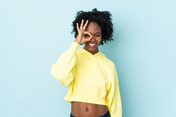 Young African American woman isolated on blue background showing ok sign with fingers