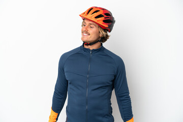Young blonde cyclist man isolated on white background looking to the side and smiling