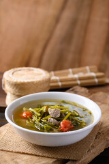 Northern Thai food (Kaeng Puk Plung), Ceylon spinach or Malabar spinach soup with pork in a bowl on wooden, Local Thai food