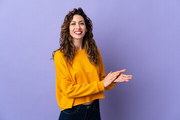 Young caucasian woman isolated on purple background applauding