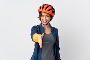 Young cyclist woman isolated on white background shaking hands for closing a good deal