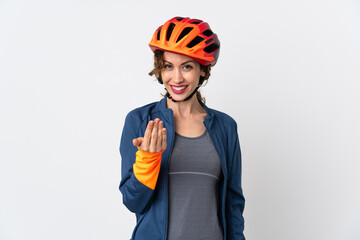Young cyclist woman isolated on white background inviting to come with hand. Happy that you came