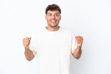 Fototapeta premium Young caucasian handsome man isolated on white background celebrating a victory in winner position