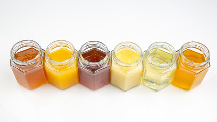 Hexagonal jars with different types and colors of fresh flower honey. vitamin food for health and life