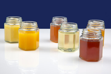 Hexagonal jars with different types and colors of fresh flower honey. vitamin food for health and...