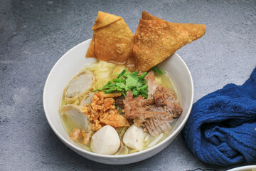 Chinese egg noodle topping slice roasted pork, fish balls, shrimp balls and wontons. Asian food style.