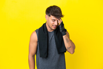 Young sport caucasian man with towel isolated on yellow background laughing