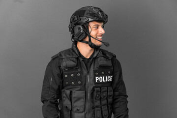 Fototapeta premium SWAT caucasian man isolated on grey background looking side