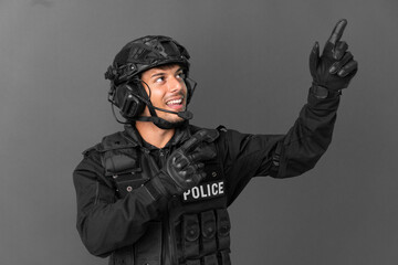 SWAT caucasian man isolated on grey background pointing with the index finger a great idea