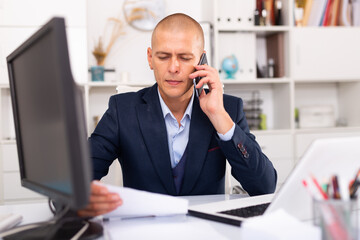 Obraz premium Man office worker deciding and talking on the phone