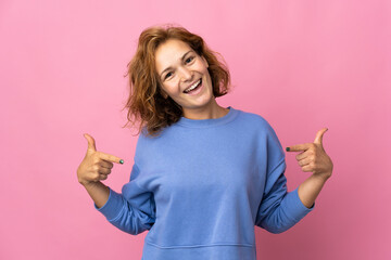Young Georgian woman isolated on pink background proud and self-satisfied
