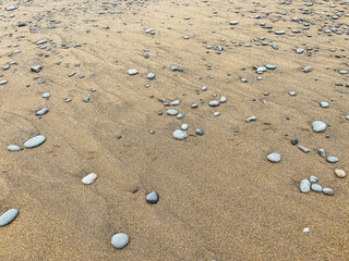 Fototapeta na wymiar bright low tide sea ocean beach sand with pebble stone rocks